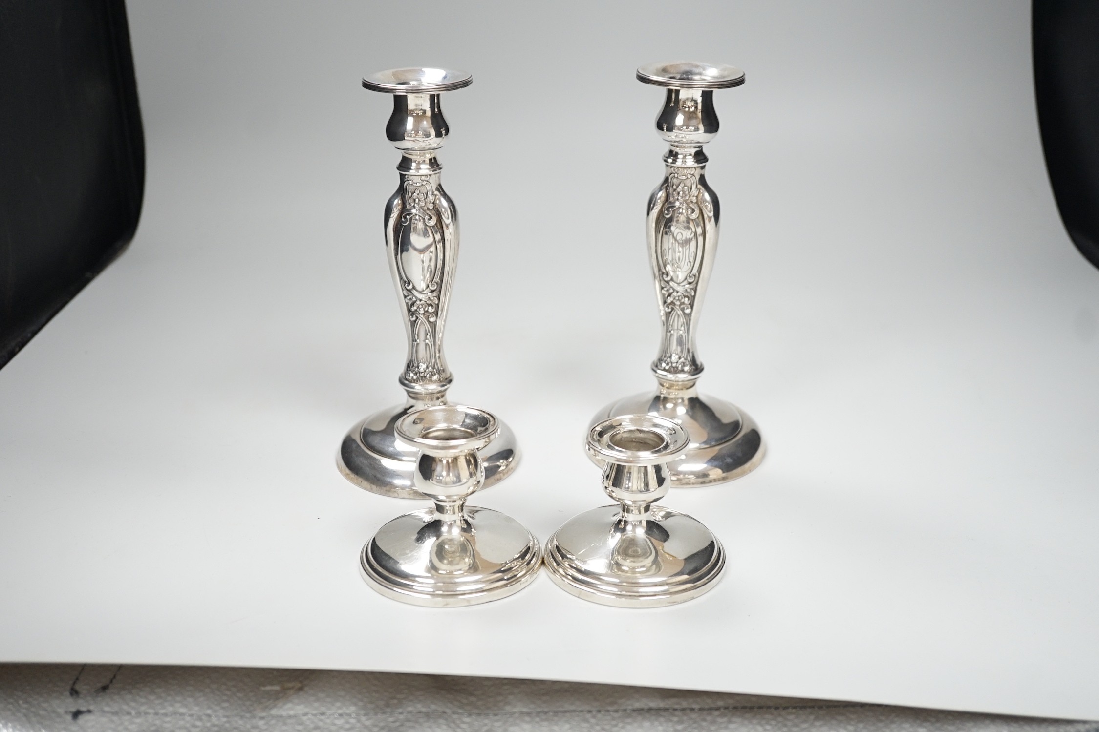 A pair of ornate sterling mounted candlesticks, 20.3cm, weighted and a pair of silver mounted dwarf candlesticks, 68mm, weighted.